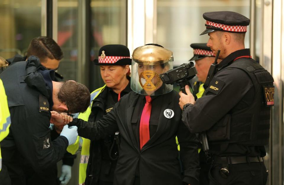 The protesters wore LED signs reading "climate emergency", "tell the truth" and "you can't eat money" (PA)