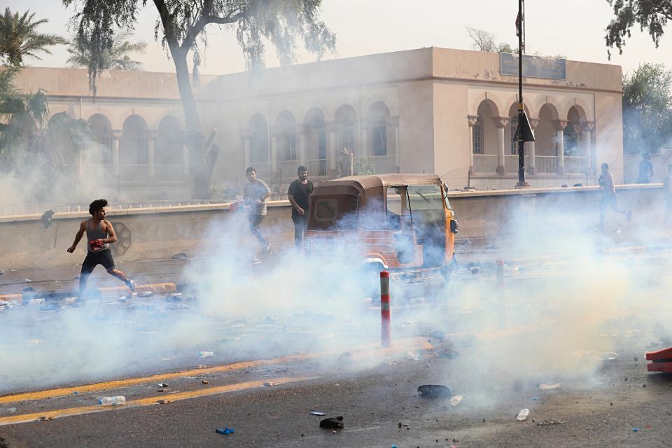 Iraqi security forces fire tear gas during a protest in Tahrir Square, in central Baghdad, Iraq, Tuesday, Oct. 1, 2019. Iraqi security forces fired tear gas on hundreds of protesters in the Iraqi capital who were demonstrating against corruption and bad public services. (AP Photo/Khalid Mohammed)