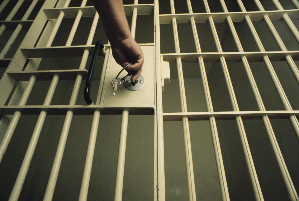 A guard locking a jail cell