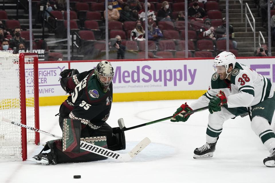 Arizona Coyotes goaltender Darcy Kuemper (35) makes a save on a shot by Minnesota Wild right wing Ryan Hartman (38) during the second period of an NHL hockey game Monday, April 19, 2021, in Glendale, Ariz. (AP Photo/Ross D. Franklin)