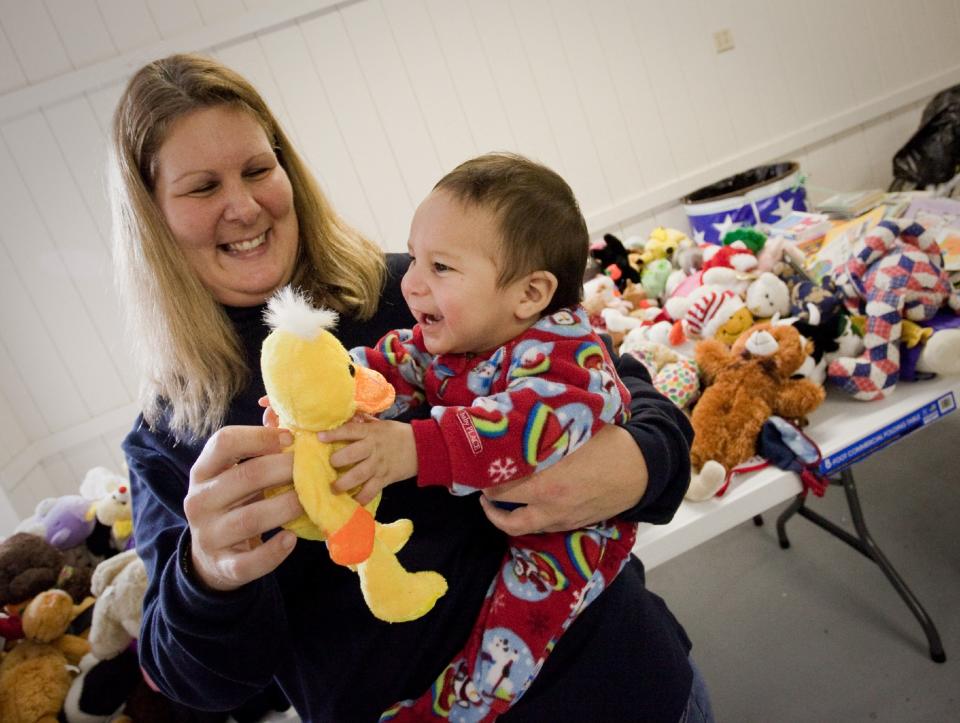 Seven-month-old Austin Reyes is elated with a stuffed animal his mom, Toni Reyes, picked for him from the multitude of toys available for kids at the 2009 J.P. Hall Sr. Children's Christmas Party.