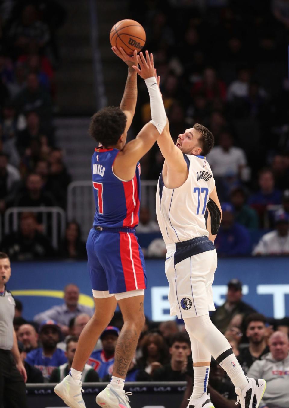 Detroit Pistons guard Killian Hayes hits a 3-pointer against Dallas Mavericks guard Luka Doncic during the fourth quarter at Little Caesars Arena in Detroit on Thursday, Dec.  1, 2022.