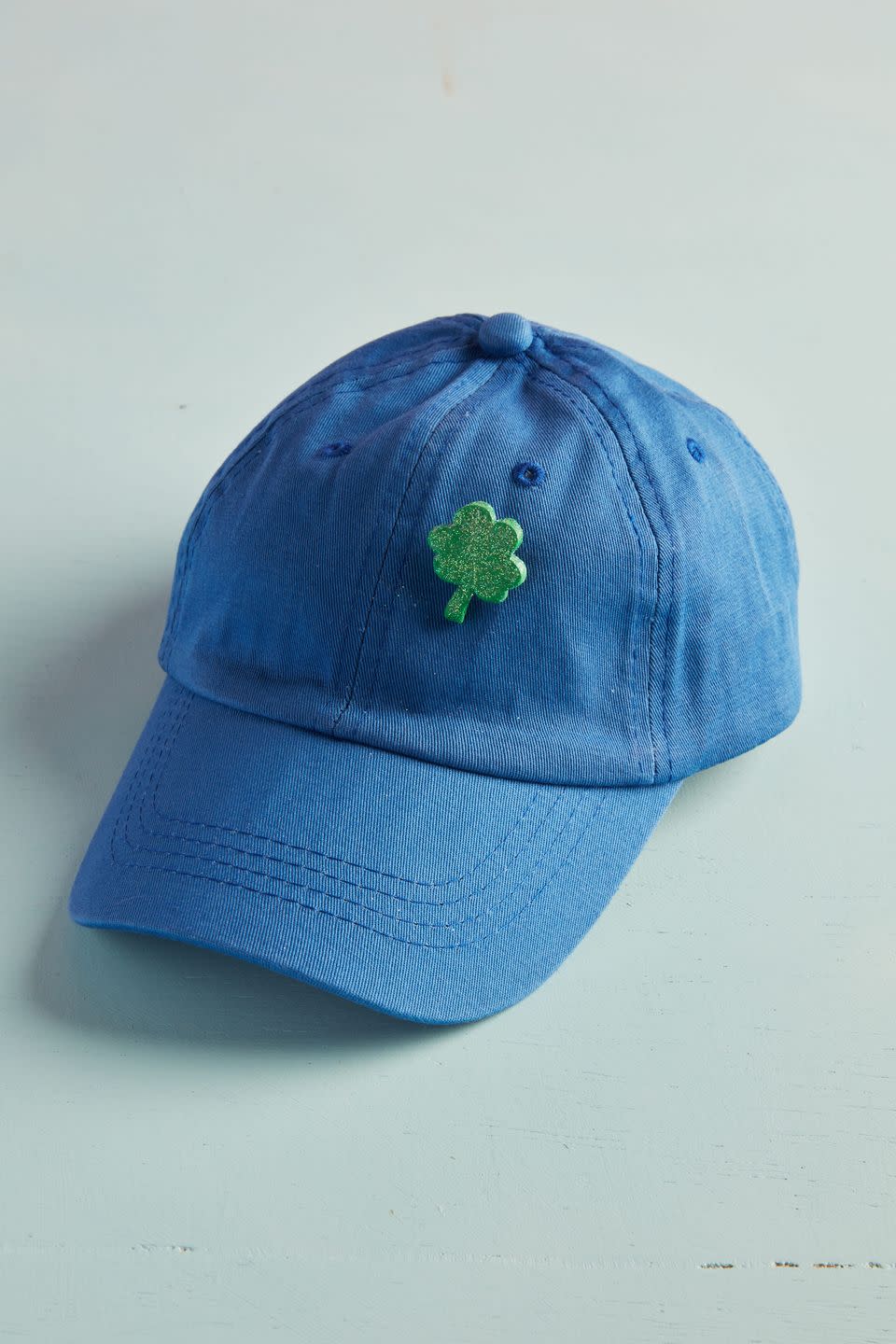 sparkly green st patricks day clover pin on a blue baseball hat
