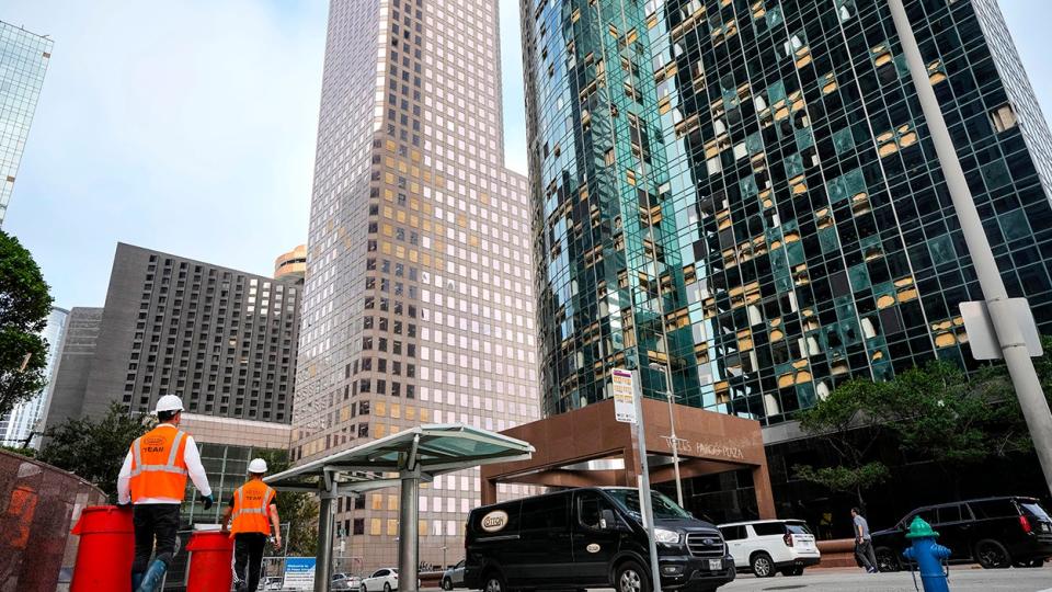 Workers clean up debris downtown on Monday, May 20, 2024 in Houston. The city closed off streets in a six-block exclusion zone downtown, from McKinney to Polk and from Smith to Travis, as workers continued to clean up broken glass from downtown streets and windows.