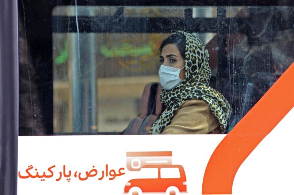 A bus passenger wears a protective mask in Tehran