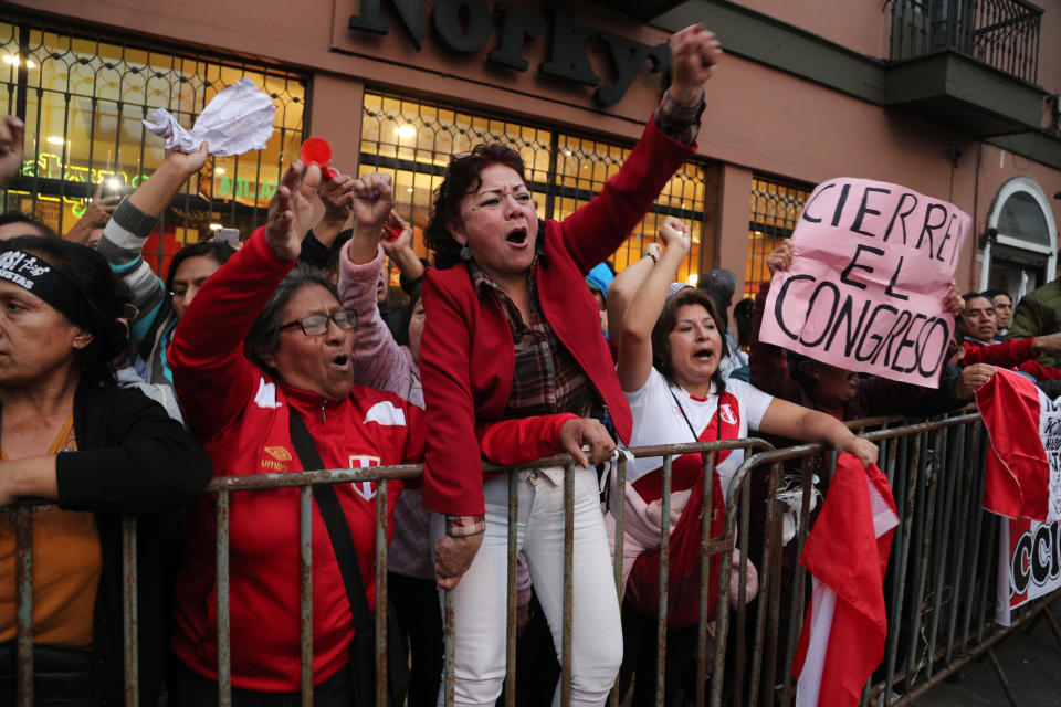 Demonstrators who had gathered to protest lawmakers pushing forward a vote to select an almost-full slate of new magistrates to the Constitutional Tribunal, celebrate after President Martin Vizcarra dissolved the legislature in Lima, Peru, Monday, Sept. 30, 2019. Lawmakers were pushing forward the vote despite Vizcarra's warning that the move threatens his fight against corruption and that he would dissolve the opposition-controlled legislature. (AP Photo/Martin Mejia)