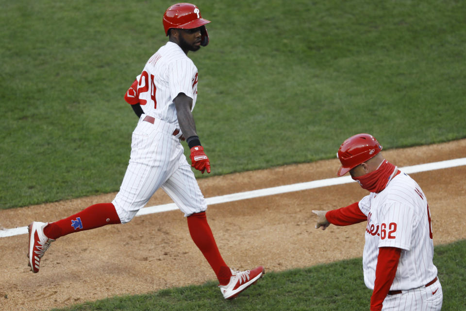 Philadelphia Phillies' Roman Quinn, left, celebrates with thirdbase coach Dusty Wathan after hitting a home run off Atlanta Braves pitcher Sean Newcomb during the second inning of a baseball game, Monday, Aug. 10, 2020, in Philadelphia. (AP Photo/Matt Slocum)