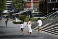 People wearing protective face masks walk along the Orchard Road shopping belt in Singapore, Friday, April 10, 2020. The Singapore government put in place "circuit breaker" measures in the light of a sharp increase of COVID-19 cases in recent days. Under the measures which will last through May 4, people have to stay home and step out only for essential tasks, such as going to work if they are in essential services, buying food and groceries, or for a short bout of exercise. (AP Photo/Yong Teck Lim)