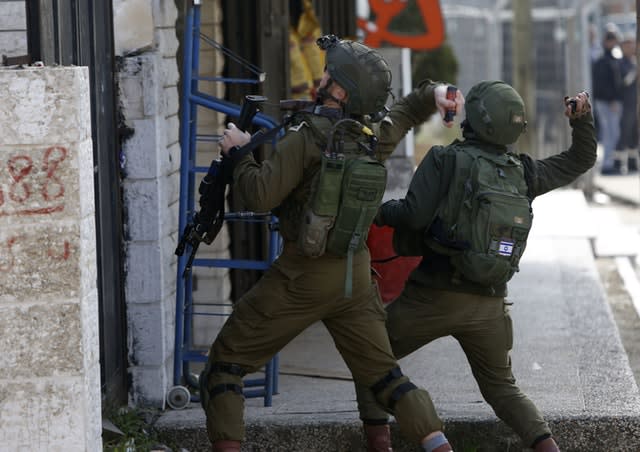 Israeli soldiers clash with Palestinians during a search for suspects