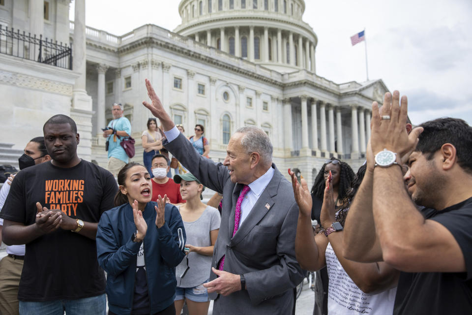 From left, Rep. Mondaire Jones, D-N.Y., Rep. Alexandria Ocasio-Cortez, D-N.Y. and Senate Majority Leader Chuck Schumer, D-N.Y., celebrate the announcement that the Biden administration will enact a targeted nationwide eviction moratorium outside of Capitol Hill in Washington on Tuesday, Aug. 3, 2021. (AP Photo/Amanda Andrade-Rhoades)