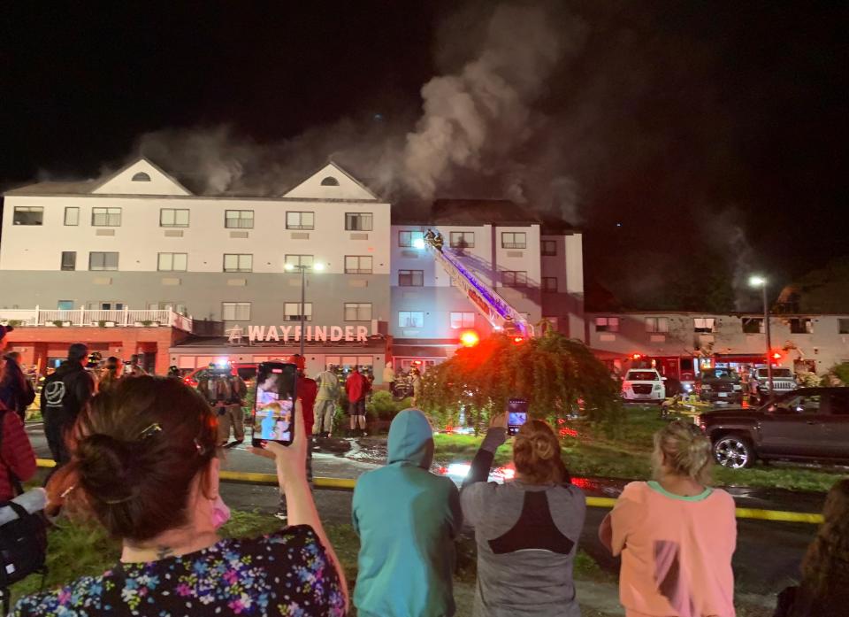 A woman takes a cellphone video of a four-alarm fire at the Wayfinder Hotel in Newport on Monday, May 23, 2022.