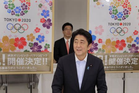 Japan's Prime Minister Shinzo Abe smiles as he reports to his cabinet members Tokyo's successful bid to host the 2020 Summer Olympics and Paralympics at the IOC meeting after returning from Buenos Aires, Argentina, during a cabinet meeting at the prime minister's official residence in Tokyo in this September 10, 2013 file photo. REUTERS/Itsuo Inouye/Pool/Files