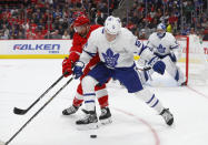 Toronto Maple Leafs defenseman Jake Gardiner (51) and Detroit Red Wings center Luke Glendening (41) compete for the puck during the second period of an NHL hockey game Thursday, Oct. 11, 2018, in Detroit. (AP Photo/Paul Sancya)