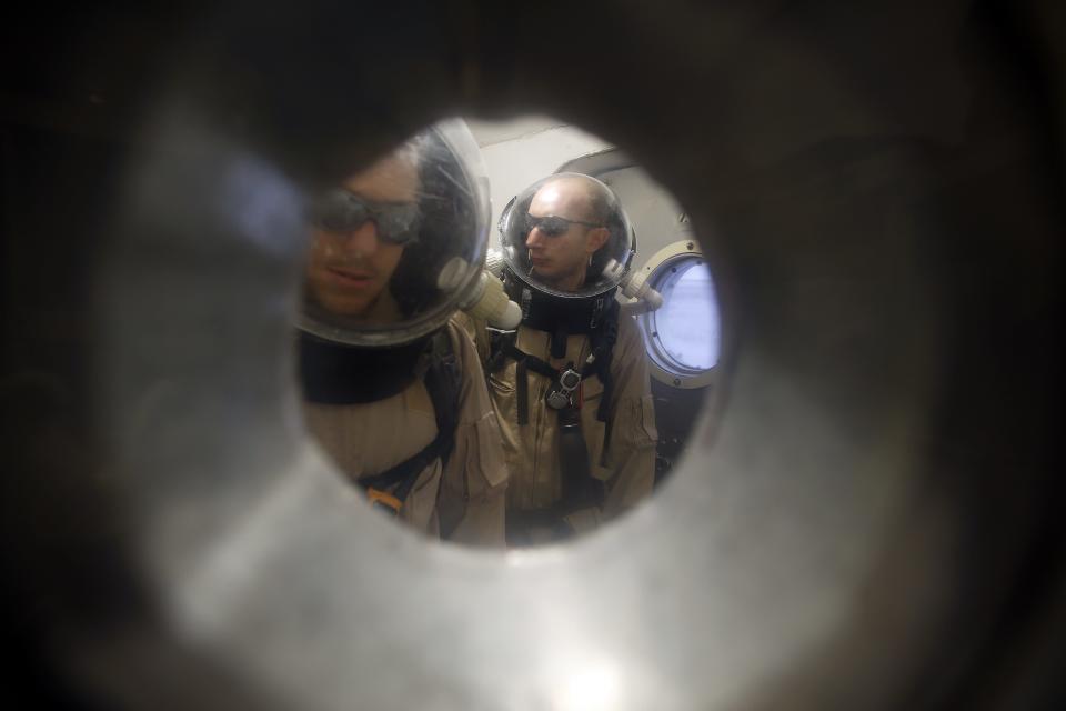 �Volker Maiwald (L), executive officer and habitat engineer, and Hans van Ot Woud, mapping researcher and health and safety officer of Crew 125 EuroMoonMars B mission of the Mars Desert Research Station (MDRS), wait in an airlock in their simulated spacesuits before venturing out to collect geologic samples in the Utah desert March 3, 2013. The MDRS aims to investigate the feasibility of a human exploration of Mars and uses the Utah desert's Mars-like terrain to simulate working conditions on the red planet. Scientists, students and enthusiasts work together developing field tactics and studying the terrain. All outdoor exploration is done wearing simulated spacesuits and carrying air supply packs and crews live together in a small communication base with limited amounts of electricity, food, oxygen and water. Everything needed to survive must be produced, fixed and replaced on site. Picture taken March 3, 2013. REUTERS/Jim Urquhart