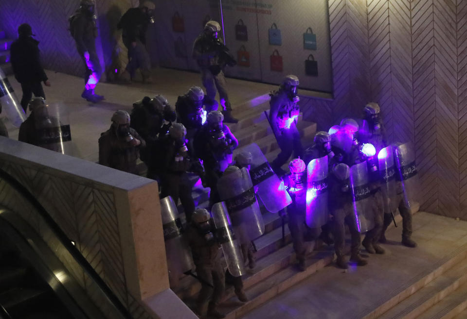 Special forces police are illuminated by laser pointers from anti-government protesters, during a protest against the new government, in downtown Beirut, Lebanon, Wednesday, Jan. 22, 2020. Lebanon's new government, made up of members nominated by the Shiite group Hezbollah and its allies got down to business Wednesday, a day after it was formed. Questions arose immediately about its ability to halt a spiral of economic and political collapse. (AP Photo/Hussein Malla)