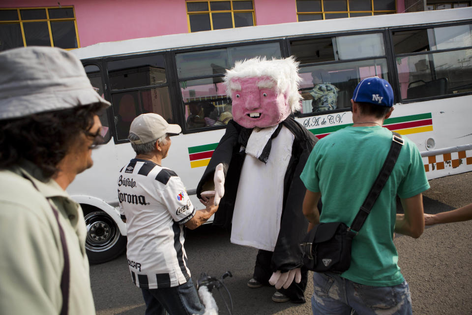 FILE - A performer dressed as presidential hopeful Andres Manuel Lopez Obrador shakes hands with supporters after a campaign rally for Delfina Gomez, who's running for governor of Mexico state with Obrador's party, the National Regeneration Movement, or MORENA, in Ecatepec, Mexico state, Mexico, May 19, 2017. A blistering display of bare-knuckled political infighting has broken out in the Morena party, complete with rumors of secret wiretaps and drug cartel ties. (AP Photo/Rebecca Blackwell, File)