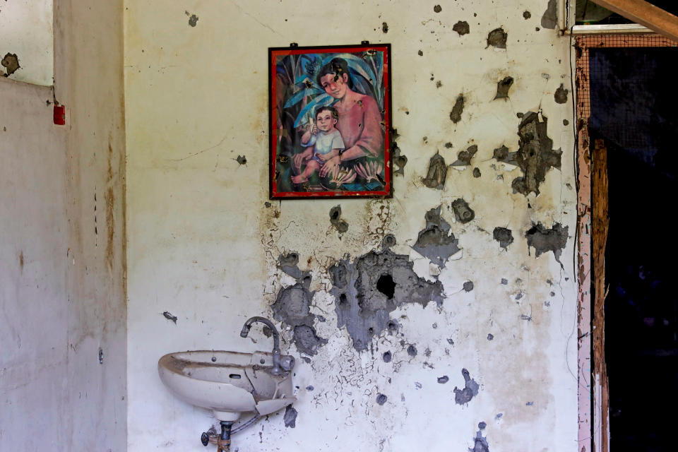 A painting of a mother and a child hangs on a wall at a bullet-riddled structure in Marawi City, Lanao del Sur province, Philippines. (Photo: Eloisa Lopez/Reuters)