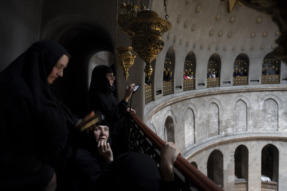Greek Orthodox nuns wait for the ceremony of the Holy Fire at Church of the Holy Sepulchre, where many Christians believe Jesus was crucified, buried and rose from the dead, in the Old City of Jerusalem, Saturday, May 1, 2021. Thousands of Christians have gathered in Jerusalem for the ancient fire ceremony that celebrates Jesus' resurrection. (AP Photo/Oded Balilty)