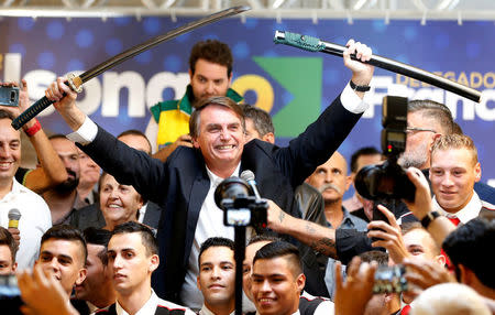 FILE PHOTO: Federal deputy Jair Bolsonaro, a pre-candidate for Brazil's presidential elections, shows a sword during a rally in Curitiba, Brazil March 29, 2018. REUTERS/Rodolfo Buhrer/File photo