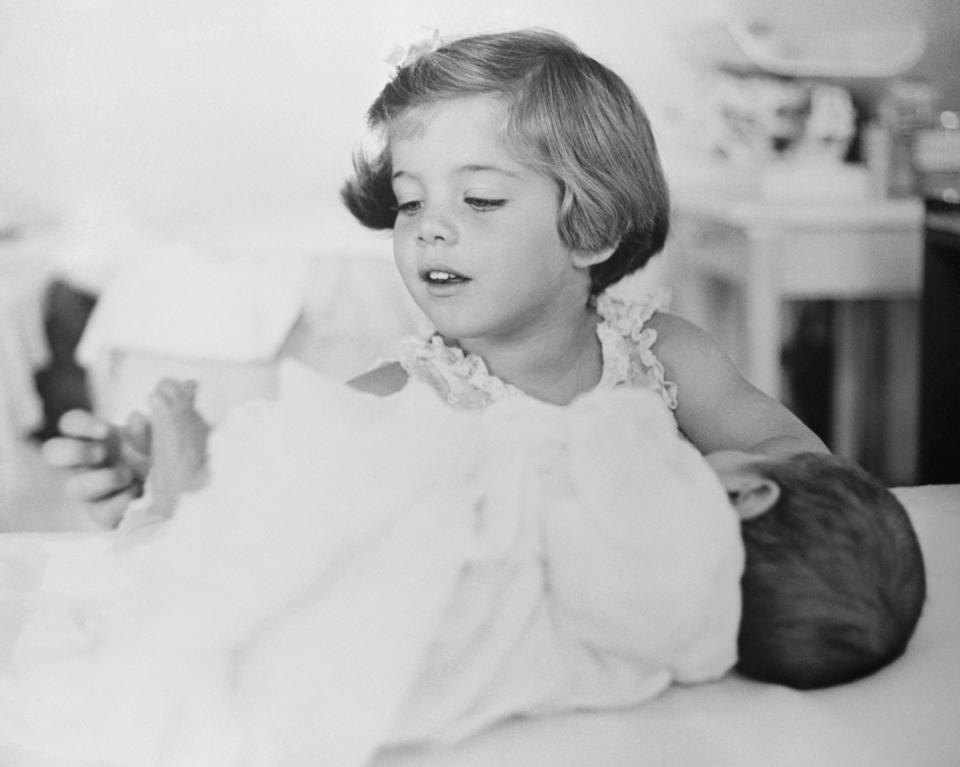 <p>Caroline plays with the toes of her baby brother, John F. Kennedy Jr. </p>