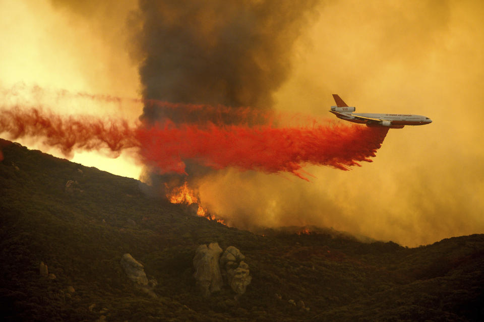 A DC-10 air tanker drops retardant to slow the Cave Fire burning in Los Padres National Forest, Calif., above Santa Barbara on Tuesday, Nov. 26, 2019. (AP Photo/Noah Berger)