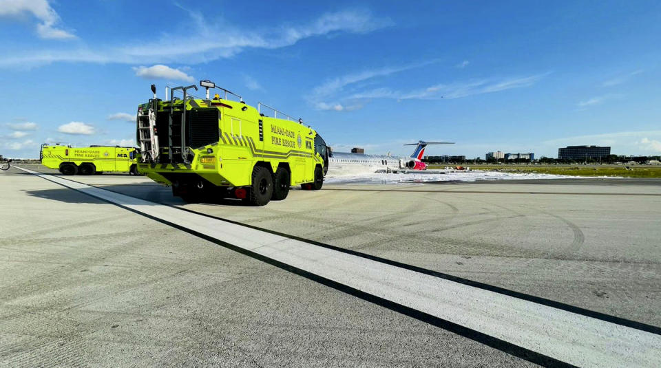 In this photo released by the Miami-Dade Fire Rescue Department, Miami-Dade Fire Rescue crews works at the scene of an aircraft fire at Miami International Airport, Tuesday, June 21, 2022. Authorities said a plane carrying 126 people caught fire after landing Tuesday at Miami International Airport, though no serious injuries were reported. (Miami-Dade Fire Rescue via AP)