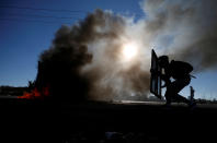 <p>A Palestinian protester takes cover during clashes with Israeli troops as Palestinians call for a “day of rage” in response to President Donald Trump’s recognition of Jerusalem as Israel’s capital, near the Jewish settlement of Beit El, near the West Bank city of Ramallah, Dec. 8, 2017. (Photo: Mohamad Torokman/Reuters) </p>