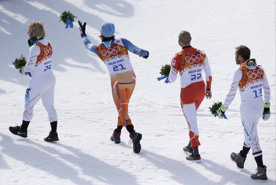 Men's super-G medalists from left, United States' Andrew Weibrecht (silver), Norway's Kjetil Jansrud (gold), Canada's Jan Hudec (bronze) and United States' Bode Miller (bronze) leave the podium after a flower ceremony at the Sochi 2014 Winter Olympics, Sunday, Feb. 16, 2014, in Krasnaya Polyana, Russia.(AP Photo/Lee Jin-man)