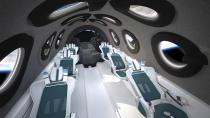 This undated photo released by Virgin Galactic shows the interior of their SpaceshipTwo Cabin during a flight. Highly detailed amenities to enhance the customer experience were shown in an online event Tuesday, July 28, 2020, revealing the cabin of the company's rocket plane, a type called SpaceShipTwo, which is undergoing testing in preparation for commercial service. There are a dozen windows for viewing, seats capable of being customized to each of six passengers and mood lighting. (Virgin Galactic via AP)