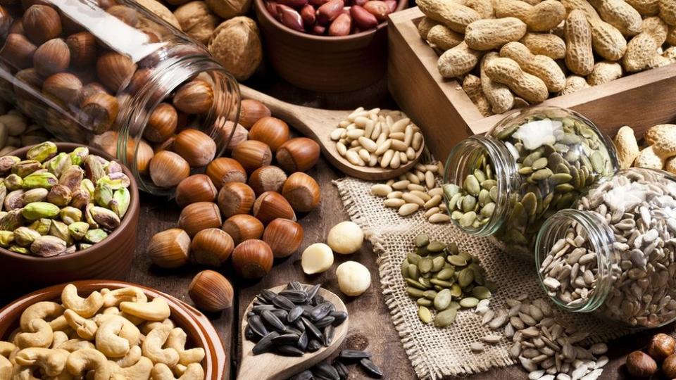 Assortment of nuts on rustic wood table.