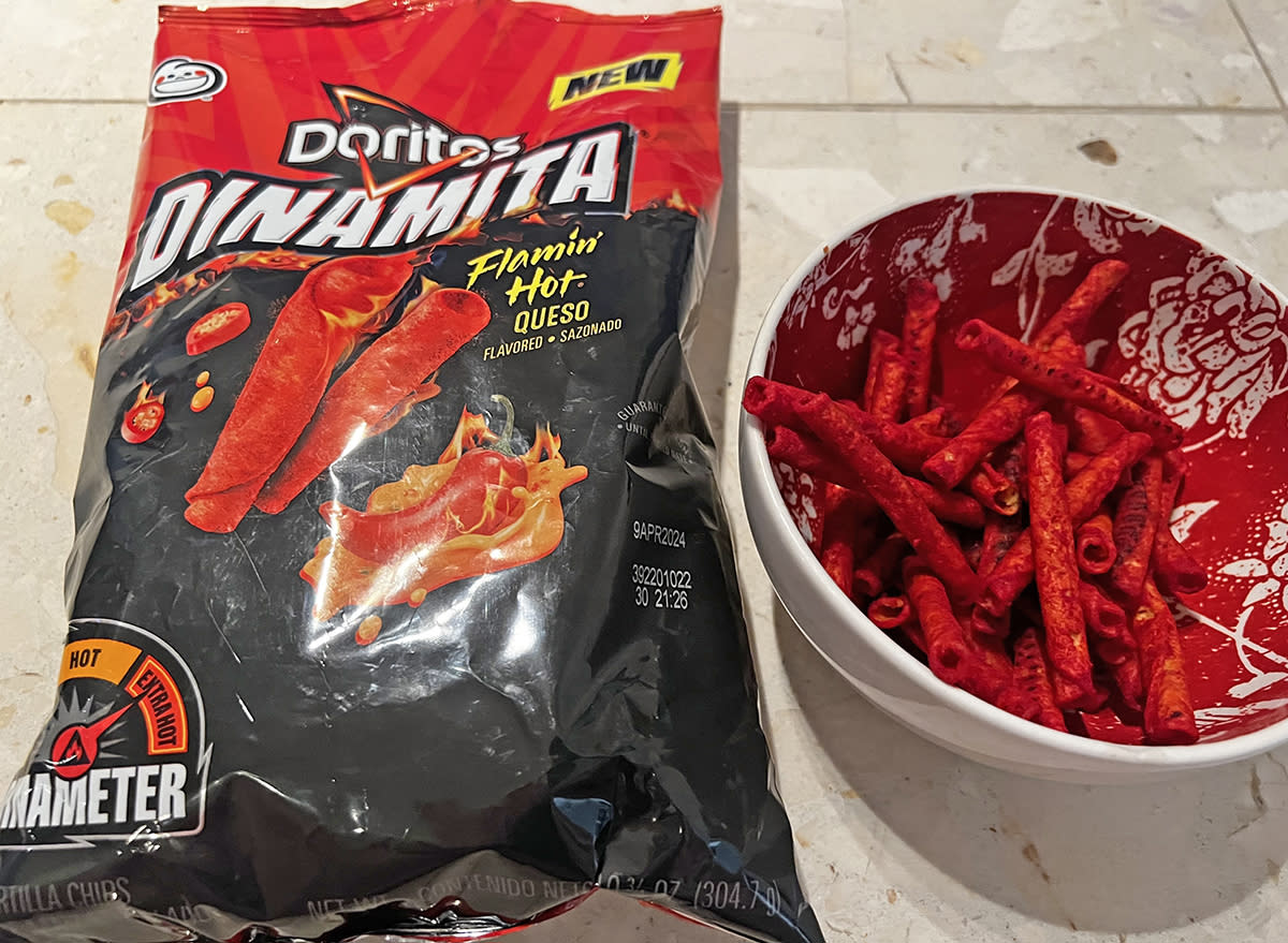 doritos dinamita flamin' hot queso chips in a bag and a bowl.