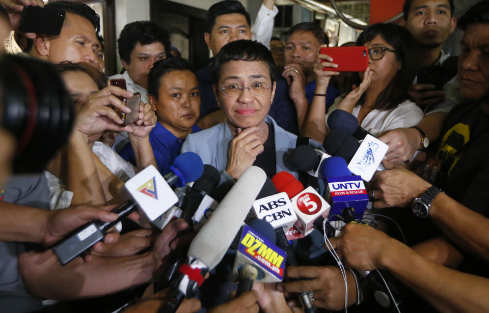 Maria Ressa, center, the award-winning head of a Philippine online news site Rappler, listens to a reporter's question after posting bail at a Regional Trial Court following an overnight arrest by National Bureau of Investigation agents on a libel case Thursday, Feb. 14, 2019 in Manila, Philippines. Ressa was freed on bail Thursday after her arrest in a libel case. (AP Photo/Bullit Marquez)