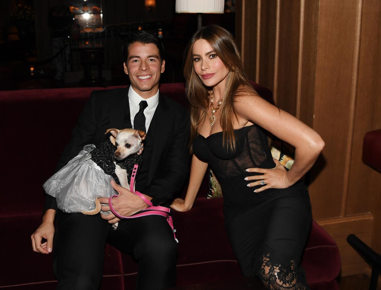 sofia vergara sitting on a couch with her son manolo and their dog