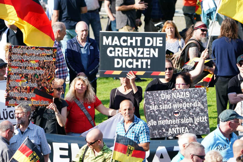 A woman holds a poster with the slogan 