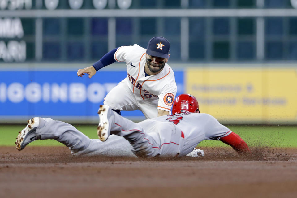 Houston Astros second baseman Jose Altuve, left, makes the tag for the out on Los Angeles Angels third baseman Taylor Ward, right, on his attempted steal during the third inning of a baseball game Tuesday, May 11, 2021, in Houston. (AP Photo/Michael Wyke)