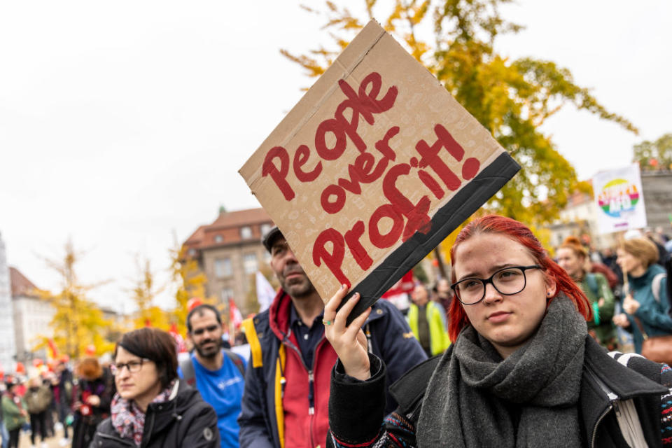 Protester hold a sign that reads "People over profits" as people march to demand a continued shift to renewable energy sources and reduction in fossil fuel dependence despite the current energy crisis on October 22, 2022 in Berlin, Germany.<span class="copyright">Maja Hitij-Getty Images</span>