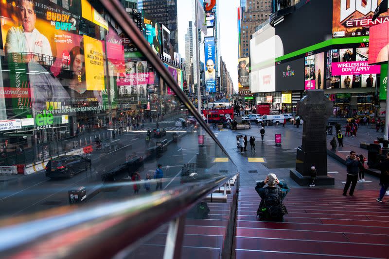 People visit Times Square while it is seen nearly empty during a regular day due to COVID-19 in New York City, New York