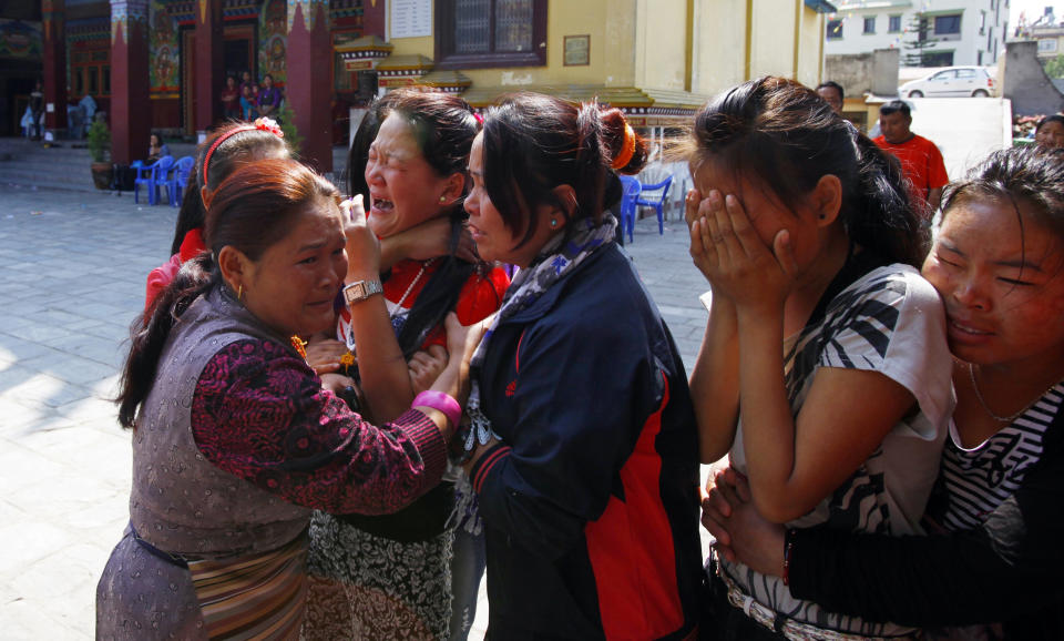 Family members of Nepalese mountaineer Ang Kaji Sherpa, killed in an avalanche on Mount Everest, cry as his body is brought to the Sherpa Monastery in Katmandu, Nepal, Saturday, April 19, 2014. Rescuers were searching through piles of snow and ice on the slopes of Mount Everest on Saturday for four Sherpa guides who were buried by an avalanche that killed 12 other Nepalese guides in the deadliest disaster on the world's highest peak. The Sherpa people are one of the main ethnic groups in Nepal's alpine region, and many make their living as climbing guides on Everest and other Himalayan peaks. (AP Photo/Niranjan Shrestha)