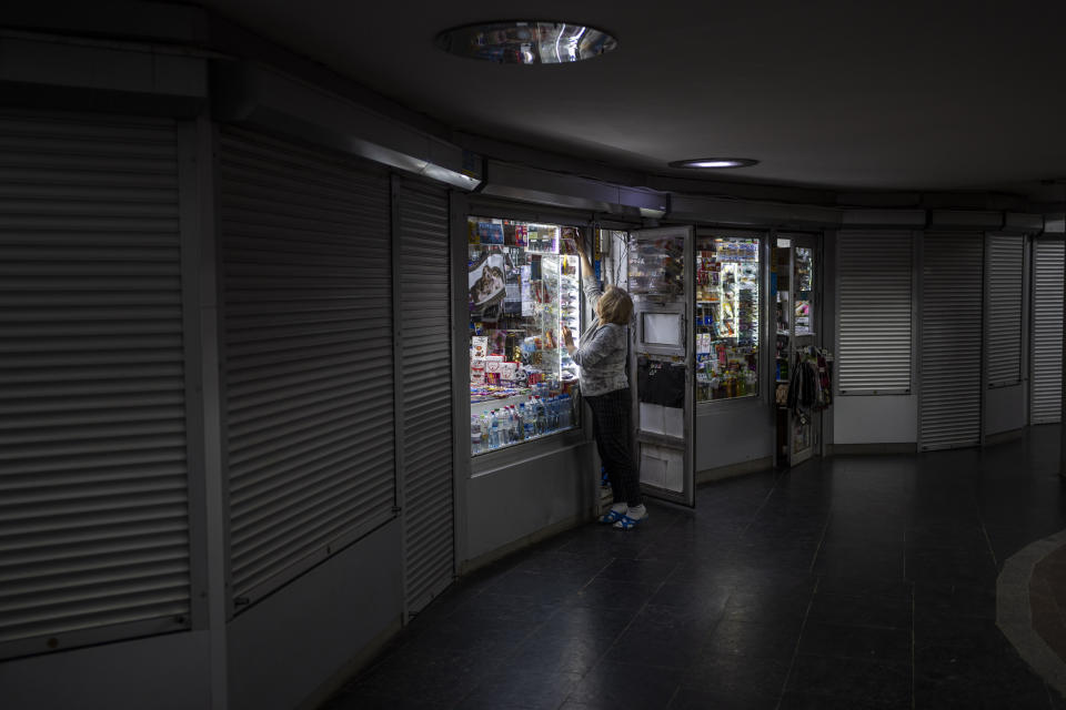 A woman arranges her shop inside the subway in Kharkiv, eastern Ukraine, Tuesday, May 24, 2022. Kharkiv subway resumed service on Tuesday morning after it was closed for more than two months during Russian attempt to capture the city. (AP Photo/Bernat Armangue)