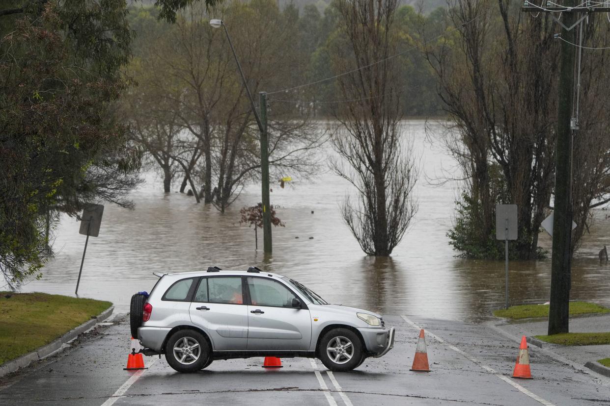 A car blocks access to a flooded street at Camden on the outskirts of Sydney, Australia, Monday, July 4, 2022.