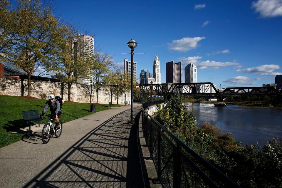 A cyclist passes through North Bank Park in downtown Columbus on a sunny afternoon in October 2021.