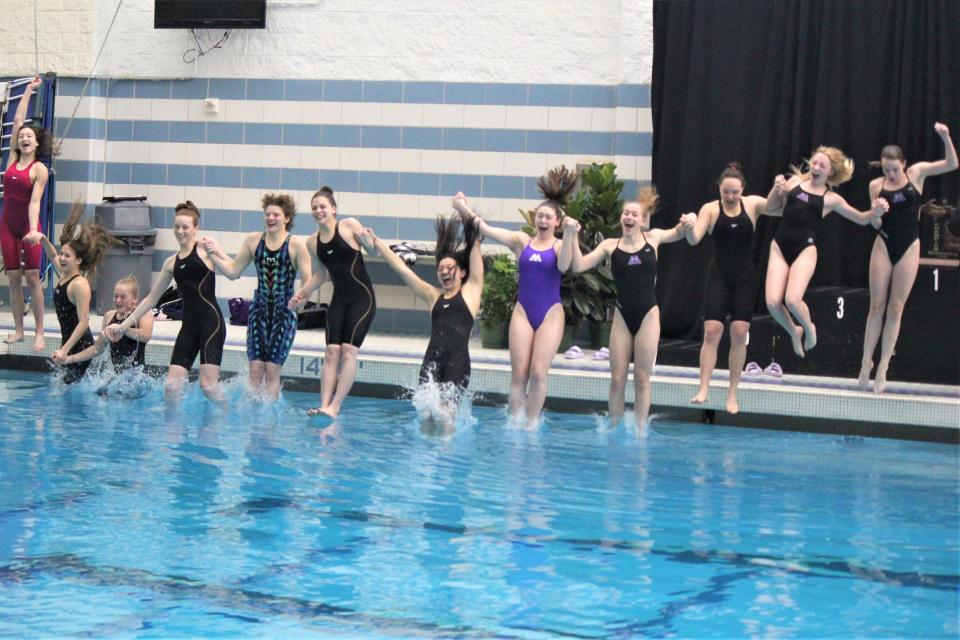 Ann Arbor Pioneer’s team takes a celebratory dunk after winning their third straight Division 1 state championship in girls swimming on Saturday, Nov. 19, 2022, on Oakland University.