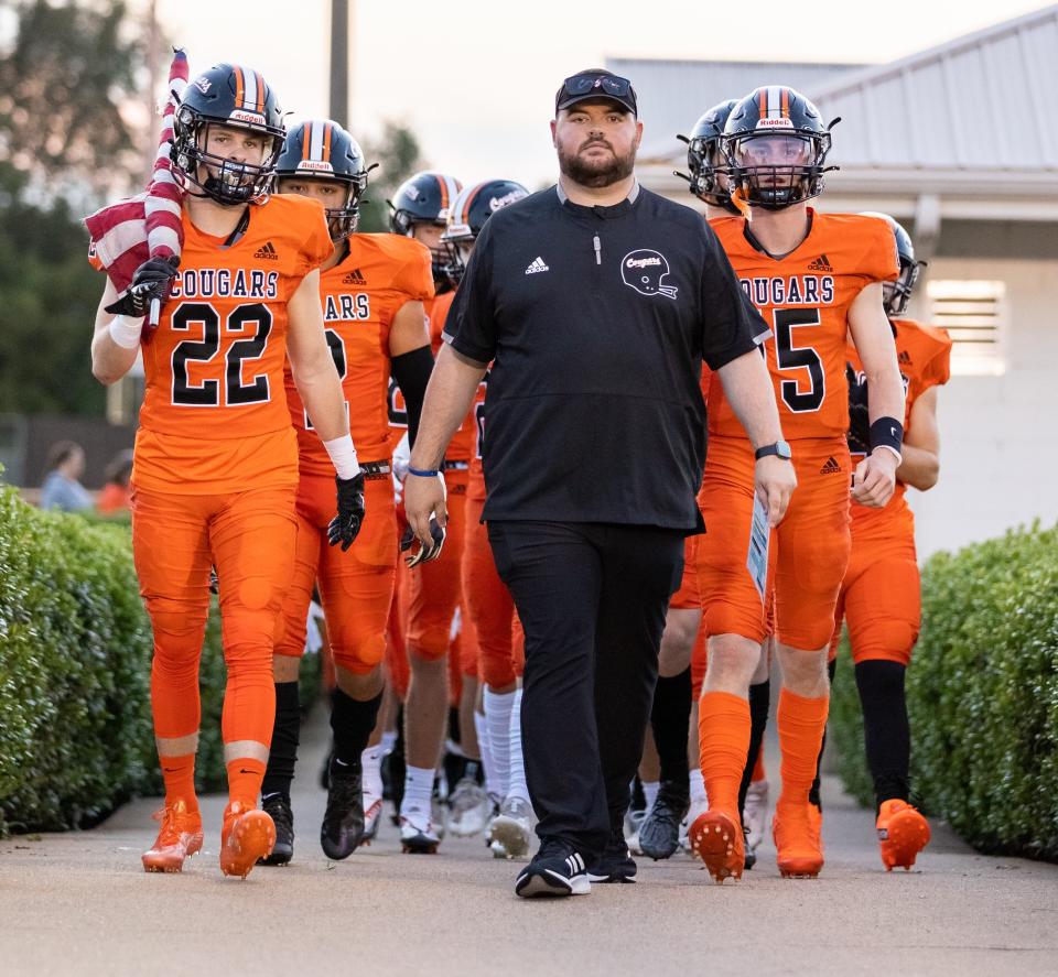 Middle Tennessee Christian's Christian Peterson leads the Cougars onto the field before a 2022 game. Peterson was named the Cougars' head coach Monday.