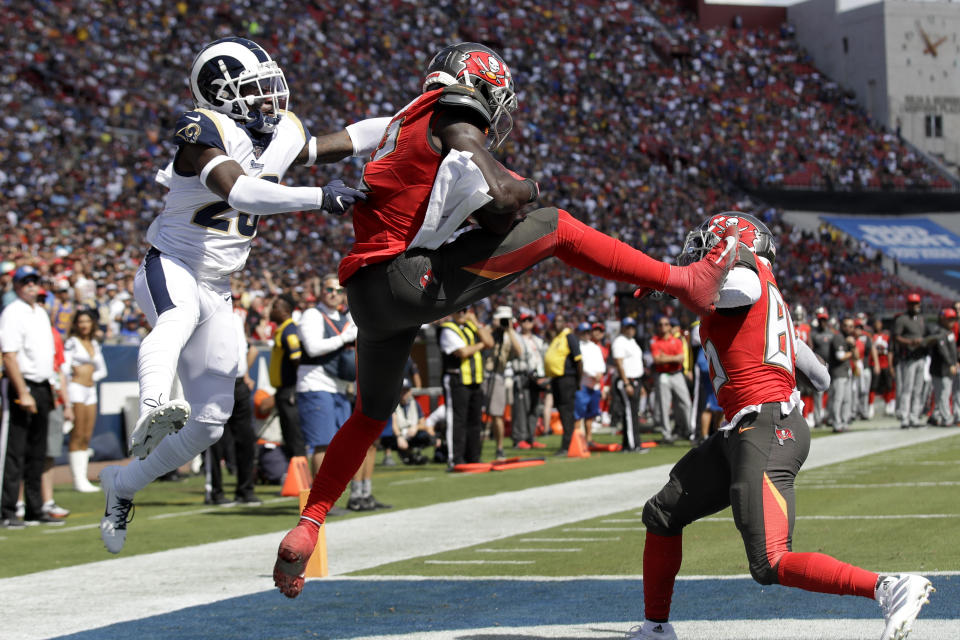 Tampa Bay Buccaneers wide receiver Chris Godwin, middle, scores ahead of Los Angeles Rams defensive back Nickell Robey-Coleman, left, during the first of an NFL football game Sunday, Sept. 29, 2019, in Los Angeles. (AP Photo/Marcio Jose Sanchez)