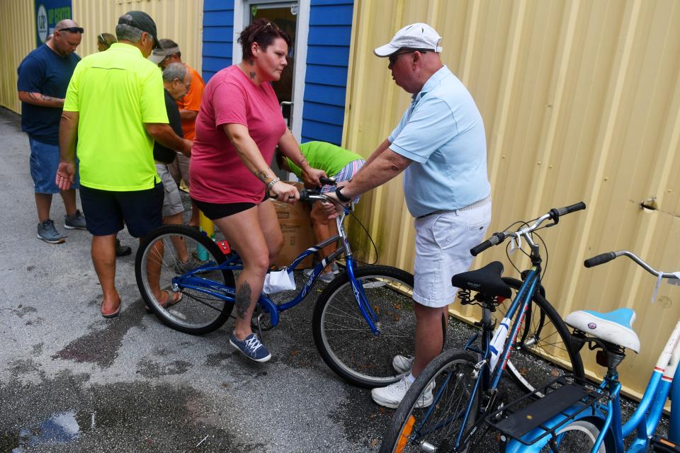 Trisha Damron talks with Dave Hunter as she is fitted with a refurbished bicycle on Wednesday, Aug. 7, 2019, after completing an hour-long safety class at United Against Poverty in Vero Beach. Each participant is given a bike, helmet, lock and lights after competing the course operated by Bike Walk Indian River County in conjunction with United Against Poverty. Unless a new storage facility can be found to house the 200 bikes currently in inventory, the 8-year-old program could come to an end.