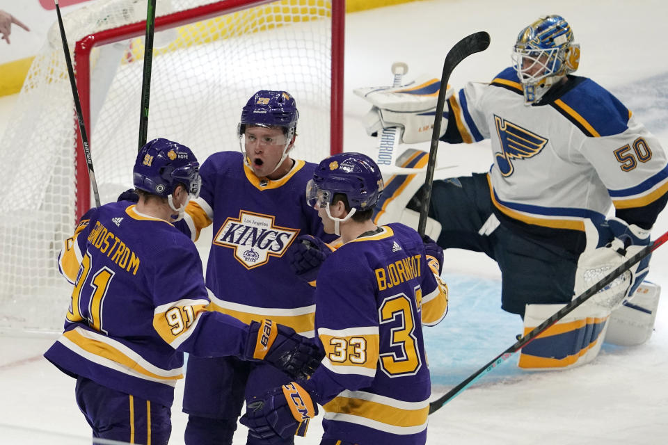 Los Angeles Kings left wing Carl Grundstrom, left, celebrates his goal with center Jaret Anderson-Dolan, second from left, and defenseman Tobias Bjornfot, second from right, as St. Louis Blues goaltender Jordan Binnington kneels in goal during the first period of an NHL hockey game Wednesday, March 17, 2021, in Los Angeles. (AP Photo/Mark J. Terrill)