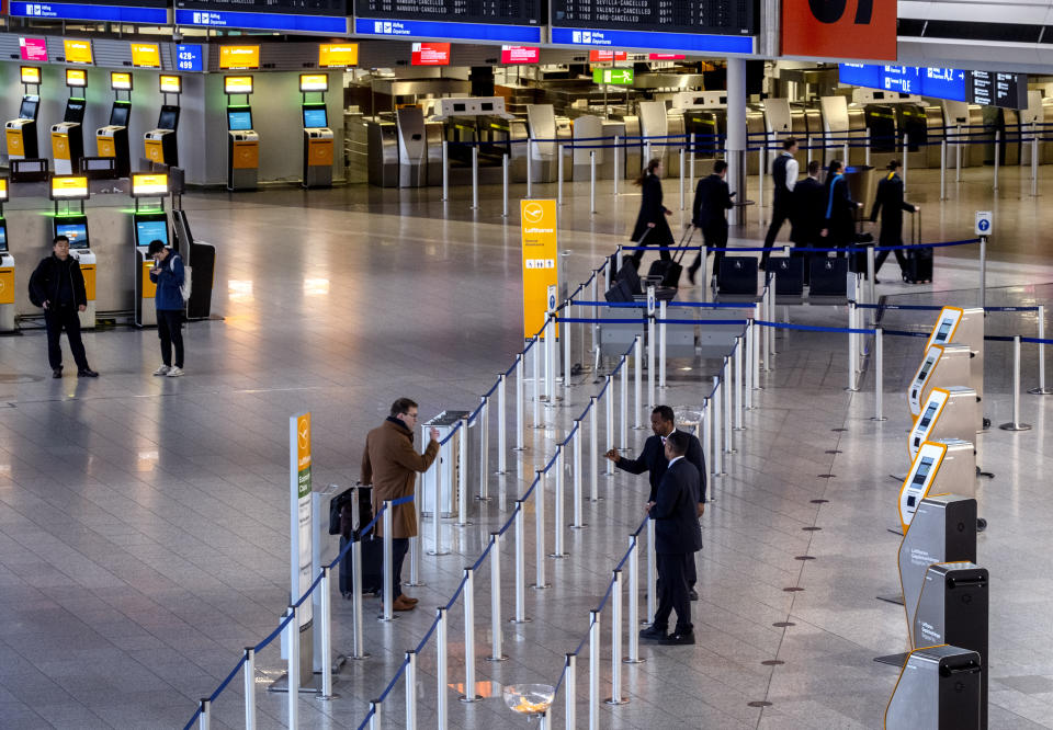 A passengers talks to airport staff in a terminal at the airport in Frankfurt, Germany, Thursday, March 7, 2024. German Lufthansa airline and the airport security staff are on a strike causing the cancellation go most of the flights. (AP Photo/Michael Probst)