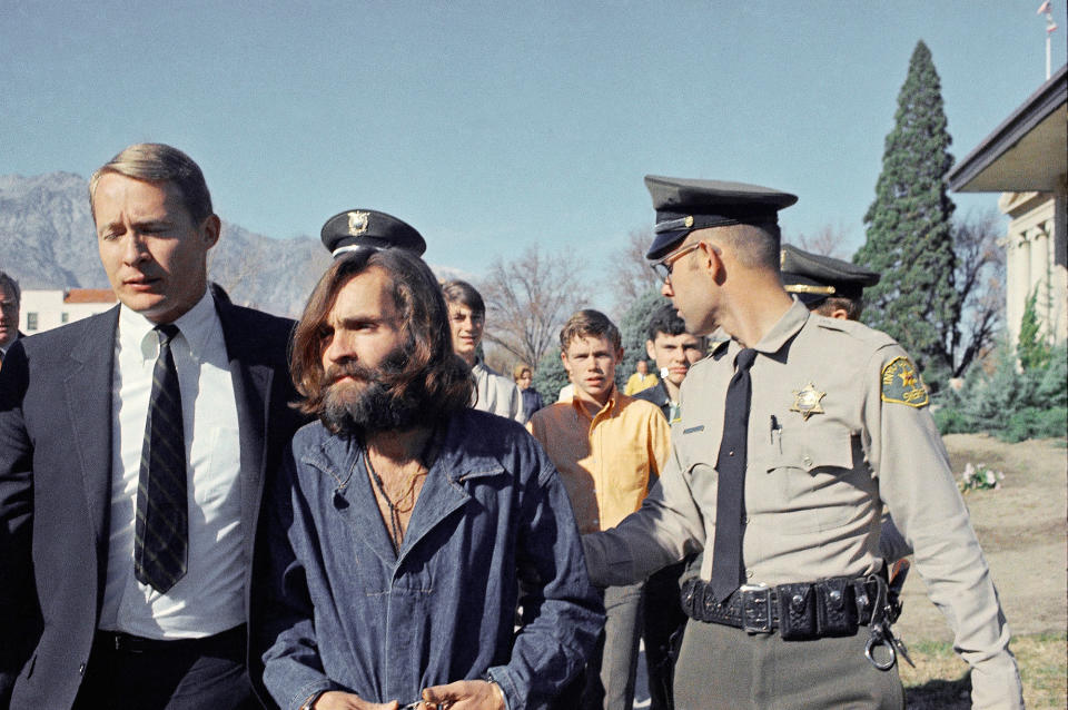 <p>Charles Manson, leader of a hippie cult linked to the Sharon Tate murders, is taken from jail to a courtroom at Independence, Calif., on Dec. 3, 1969, for a preliminary hearing on charges of possessing stolen property. At left is his public defender, Fred Schaefer. (Photo: AP) </p>