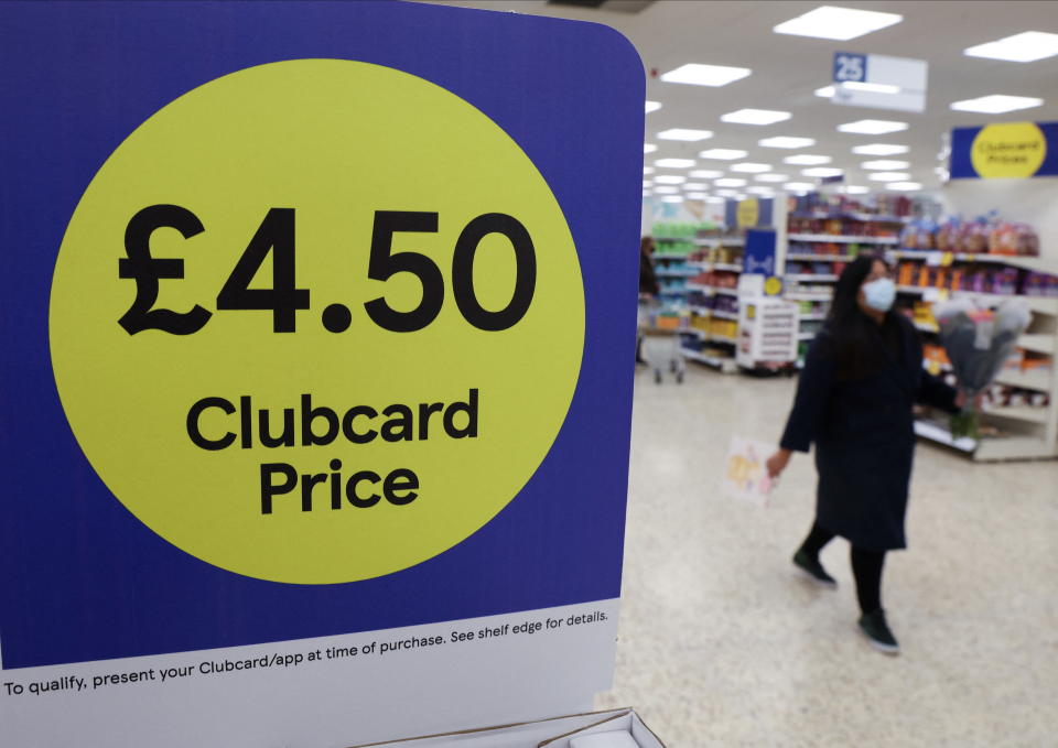 A shopper walks next to the clubcard price branding inside a branch of a Tesco Extra Supermarket in London, Britain, February 10, 2022. Picture taken February 10, 2022. REUTERS/Paul Childs