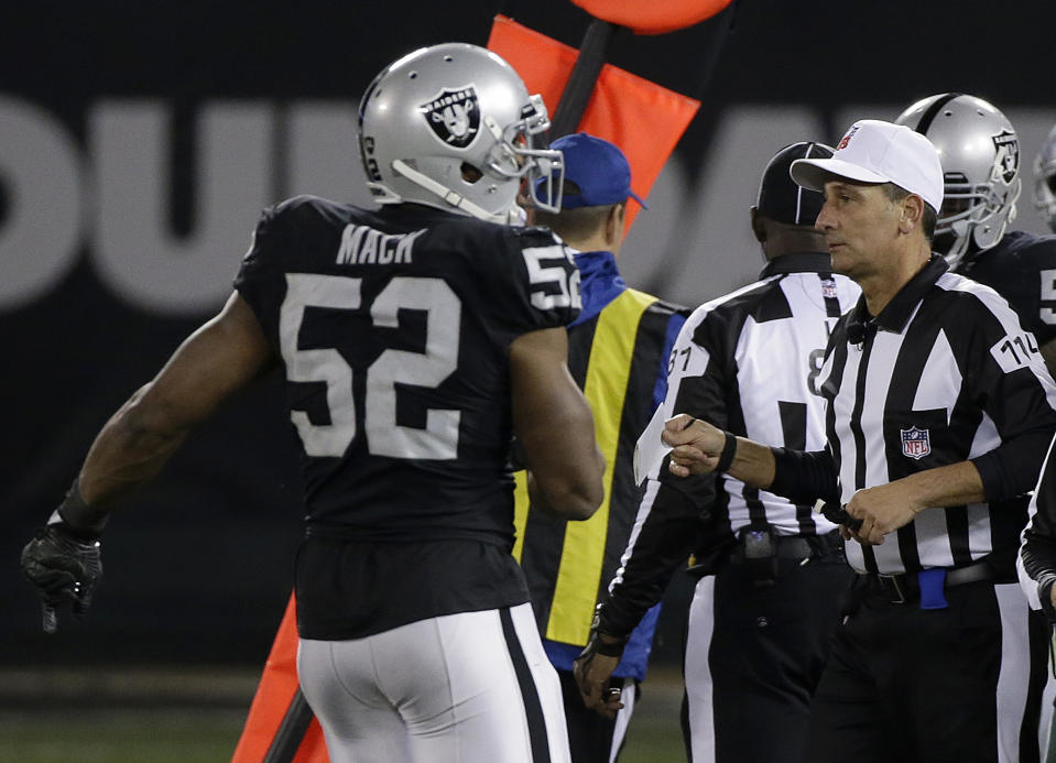 Referee Gene Steratore carries a folded piece of paper he used to determine a measurement during Sunday’s Oakland-Dallas game. Officials have been told not to use paper anymore. (AP)